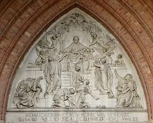 Steinrelief über einem Kirchenportal; Jesus mit Nachfolgern.
